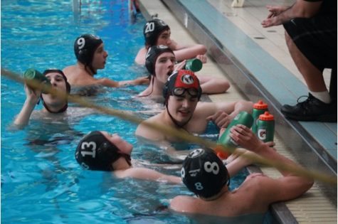 The team on a water break during an intense game. Photo Credit: Joe Bendig